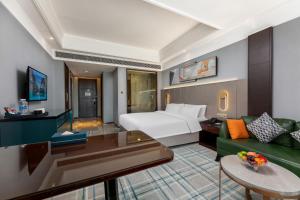 江岸Wuhan Jingmao Wanda Jinhua Hotel的配有床和沙发的酒店房间