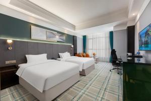 江岸Wuhan Jingmao Wanda Jinhua Hotel的有两张床和一台电视的酒店房间