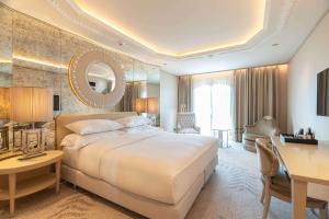 a hotel room with a large bed and a desk at Wyndham Grand Istanbul Kalamış Marina Hotel in Istanbul