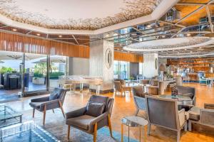 a lobby with chairs and tables and a bar at Wyndham Grand Istanbul Kalamış Marina Hotel in Istanbul
