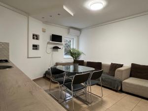 a living room with a table and a couch at NMG APARTMAN - Péter utca in Pécs