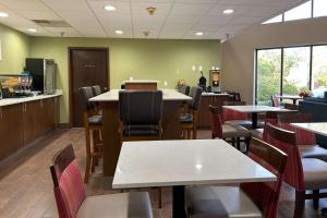 a restaurant with tables and chairs and a kitchen at Quality Inn & Suites Tarboro - Kingsboro in Tarboro