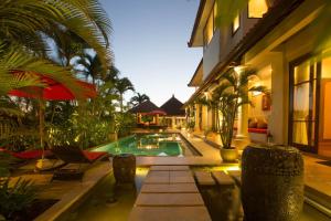 a courtyard with a swimming pool and a building at Villa Padi in Canggu