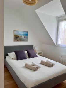 a bedroom with a large bed with two pillows on it at Charmante maison familiale in Ouistreham