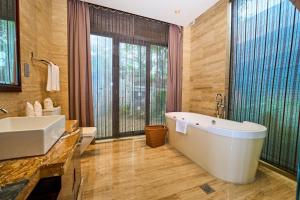 a bathroom with a large tub and a sink at Grand Metropark Villa Resort Sanya Yalong Bay - Beach shuttle and Singer performance in Sanya +53 photos