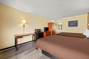 a hotel room with two beds and a desk at Rodeway Inn Monroe in Monroe