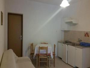 a room with a table and a kitchen with a table and chairs at Apartments Boguvila - One-Bedroom Apartment with Terrace A3 - ST in Supetar +5 photos