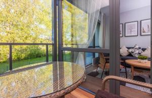 a room with a balcony with a glass table at Šventosios uostas in Palanga