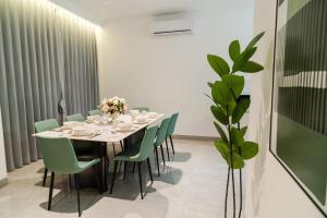 a dining room with a table and green chairs at Georgetown Greenish Kid-Friendly KTV 3BR 15pax B in George Town +36 photos