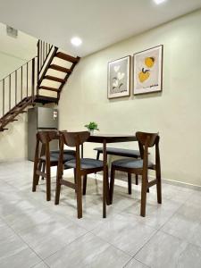 a dining room with a table and chairs and a staircase at Modern and Cozy home in the heart of Segamat in Segamat