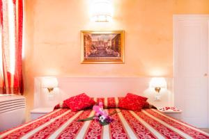 a bedroom with a bed with red pillows and a painting at Domus Trevi in Rome