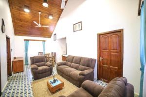 a living room with a couch and chairs and a door at Anudhyana Premium Private Stone Villa Vagamon by VOYE HOMES in Vagamon