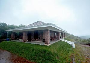 a small building with a porch on a hill at Anudhyana Premium Private Stone Villa Vagamon by VOYE HOMES in Vagamon +16 photos