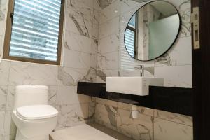 a bathroom with a white toilet and a mirror at Georgetown Bright & Kid-Friendly KTV 3BR 15pax C in George Town