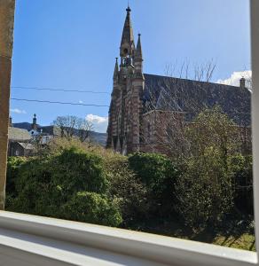 an old stone building with a clock tower on it at Glebe Apartment in Campbeltown