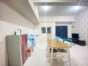 a kitchen and dining room with a table and a refrigerator at Pleasant 2BR Apartment at Newton Residence By Travelio in Bandung