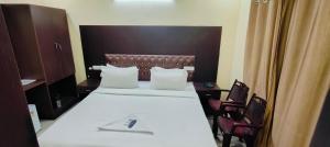 a hotel room with a bed and two chairs at Pph Royal GS Comforts Opp Mall of Asia in Bengaluru