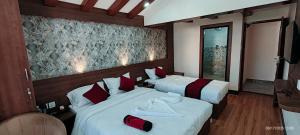 una camera d'albergo con due letti con cuscini rossi di Lazimpat Boutique Hotel a Kathmandu