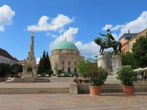 a statue of a man on a horse in front of a building at NMG Apartman - Megyeri tér in Pécs +3 photos