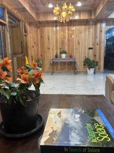 a room with a potted plant and a book on a table at Yangsel Homestay in Dirang Dzong +1 photo