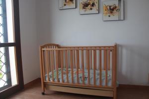 a crib in a room with pictures on the wall at B&B La Terrazza di Frascati in Frascati