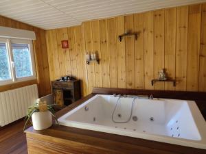 a large bath tub in a room with wooden walls at La Marie Galante Appart'Hotel in Saint-Georges-dʼOléron +19 photos