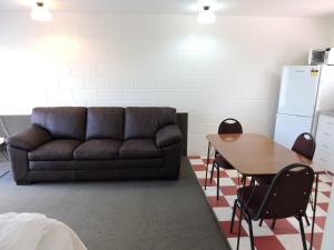 a living room with a couch and a table at Maple Lodge Motel in Matamata