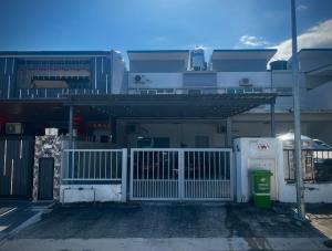 a building with a white gate and a parking lot at Homestay Adyana in Raub