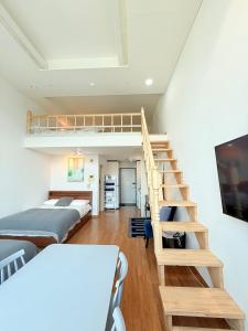 a room with two beds and a staircase at Miumi Duplex House Hong Dae in Seoul