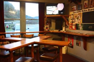 a restaurant with wooden tables and chairs and a television at Owen River Tavern & Motels in Owen River