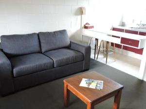 a living room with a couch and a coffee table at Maple Lodge Motel in Matamata
