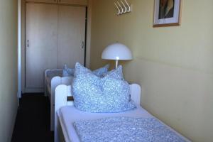 Zimmer mit einem Bett mit blauen Kissen und einer Lampe in der Unterkunft Ferienappartement E226 für 2-4 Personen an der Ostsee in Brasilien
