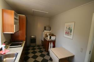 a small kitchen with a checkered floor at Hellerup Bed & Breakfast in Løgstrup