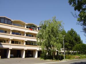 un grande edificio bianco con un albero di fronte di Ferienwohnung F334 für 2-4 Personen an der Ostsee a Schönberg in Holstein