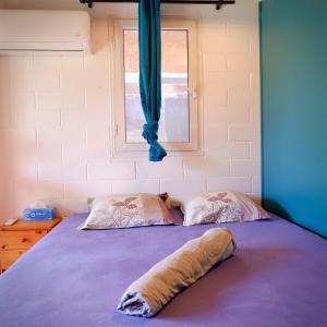 厄唐萨雷Kaz de pêcheur Les Bains的一张带两个枕头的床和窗户 更多2张照片