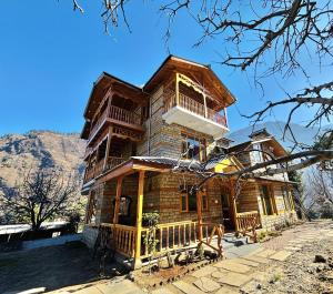 a large wooden house with a balcony on top at Soma Serene Stays in Nagar +22 photos