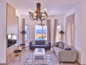 a living room with a blue couch and a chandelier at Villa Melissa Kaş Peninsula in Kaş