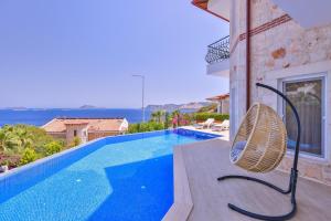 a villa with a swimming pool and a chair at Villa Melissa Kaş Peninsula in Kaş