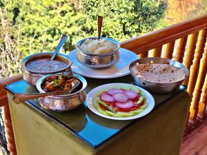 a tray with bowls of food and plates of food at Soma Serene Stays in Nagar