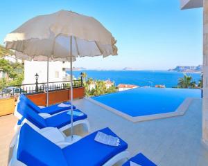a group of blue chairs and an umbrella next to a swimming pool at Villa Melissa Kaş Peninsula in Kaş