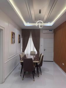 Un comedor con una mesa y sillas y una lámpara de araña. en Savvy Residences, en Abuja 8 fotos más