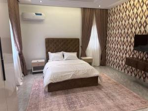 Un dormitorio con una cama grande y una alfombra. en Savvy Residences, en Abuja