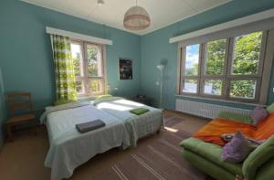a bedroom with a large bed and a couch at Kuohuvirran kartano in Nummistenkylä