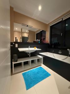 a bathroom with a tub and a sink and a bath tub at Urban Luxus trifft Naturidylle in Bönningstedt