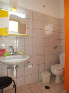 a bathroom with a sink and a toilet and a mirror at Firefly Studios Panayiota 16 in Moraitika