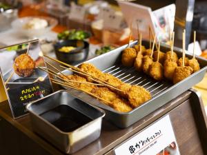a buffet with meat skewers and food on a grill at Hotel Wing International Premium Osaka-Shinsekai in Osaka