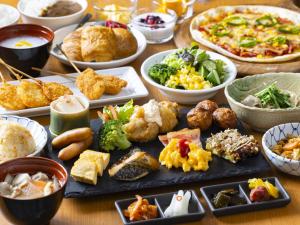 a table topped with different types of food on plates at Hotel Wing International Premium Osaka-Shinsekai in Osaka