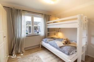 Un dormitorio con una litera con un perro. en 27 Ferienwohnung an der Reiterkoppel 49a EG, en Burg auf Fehmarn