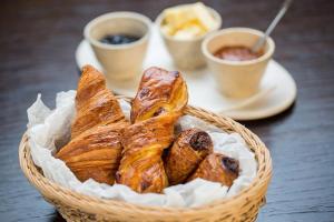 Una cesta de pasteles sobre una mesa con tazas de café. en W33 - Prime Location - Comfortable Quality Apartments by BQA, en Budapest