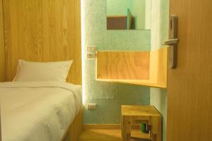 a small bedroom with a bed and a table at Boxtel @ Suvarnabhumi Airport in Lat Krabang